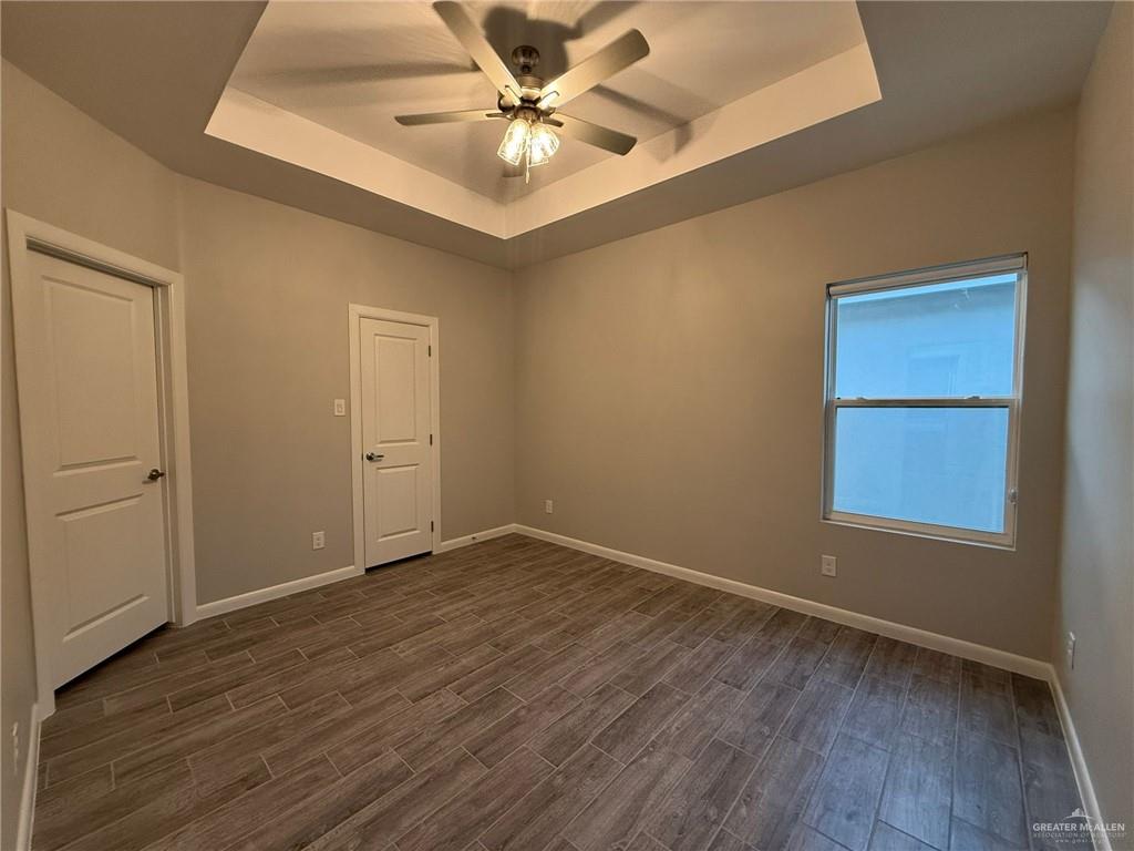 809 Dove Avenue, Unit 4 Edinburg, TX 78542 - Photo 6 of 19 an empty room with wooden floor and windows