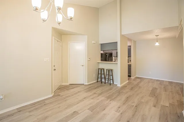 an empty room with wooden floor fireplace and windows