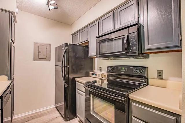 a kitchen with stainless steel appliances granite countertop a sink refrigerator and cabinets