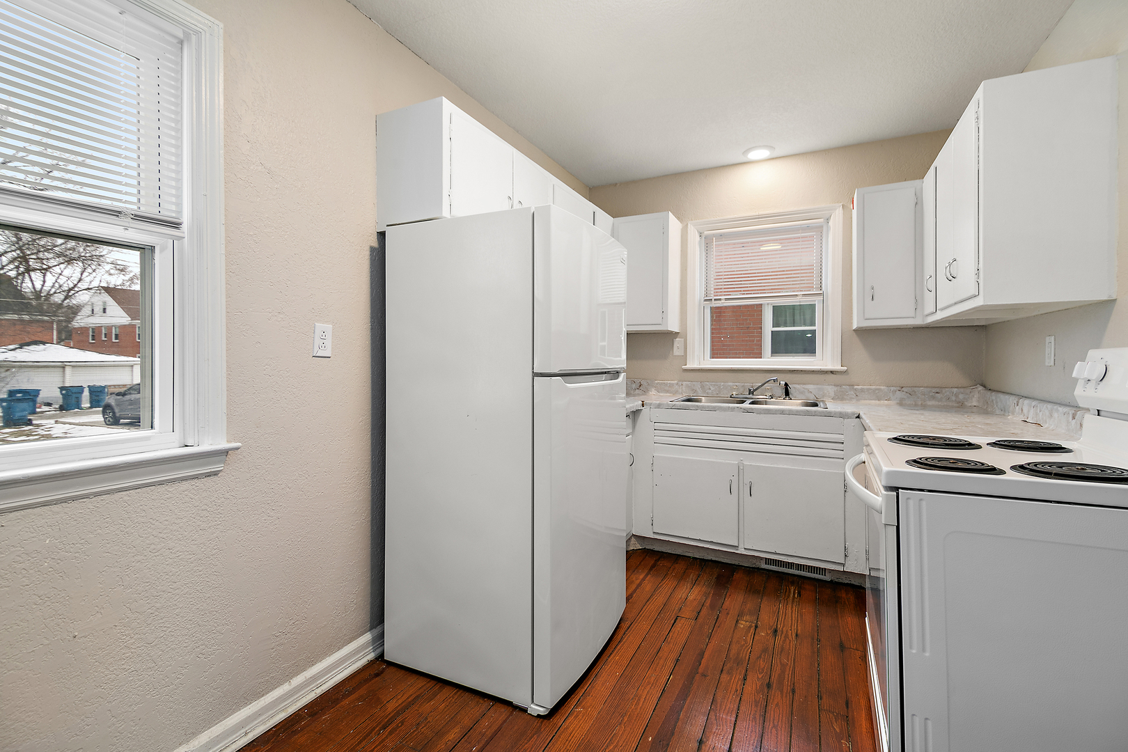 381 South Nelson Avenue Kankakee, IL 60901 - Photo 7 of 15 a kitchen with stainless steel appliances a refrigerator a sink and white cabinets with wooden floor