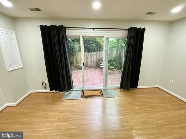 a view of a room with wooden floor and a large window