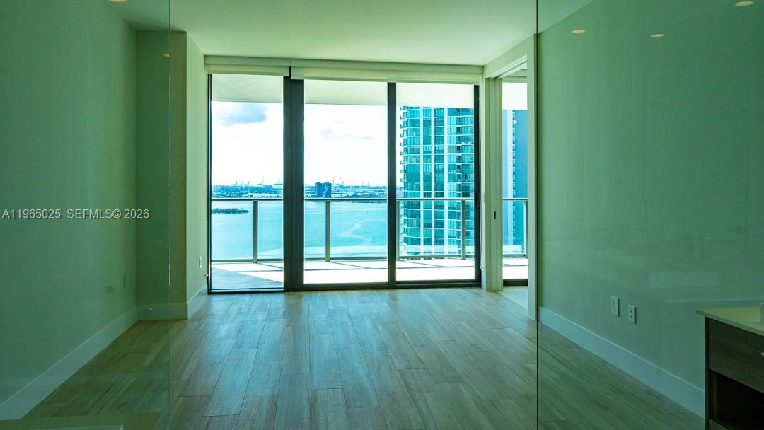 650 Northeast 32nd Street, Unit 2105 Miami, FL 33137 - Photo 8 of 61 a view of an empty room with wooden floor and a window