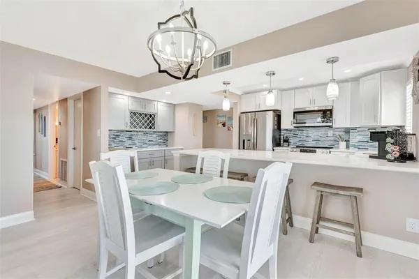 a kitchen with a sink dishwasher and white cabinets with wooden floor
