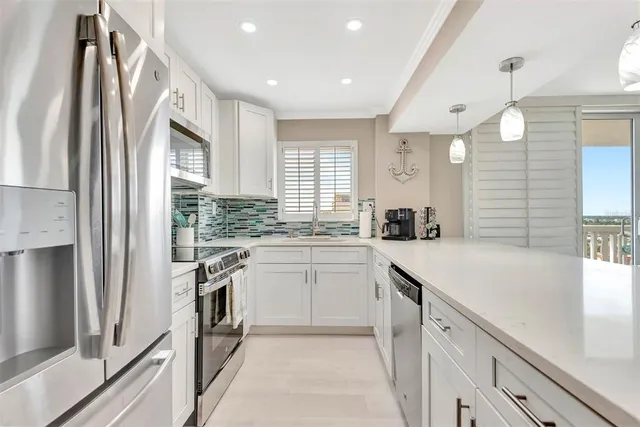 a kitchen with kitchen island a sink stainless steel appliances and cabinets