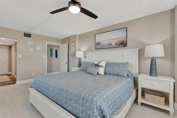 a bedroom with a large bed and a flat tv screen