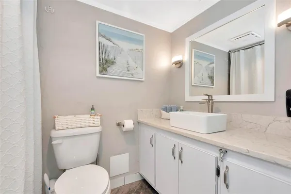 a view of a hallway with bathroom and wooden floor