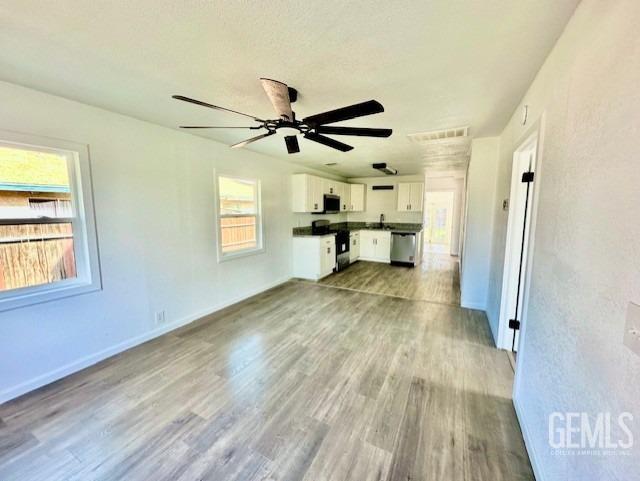 Undisclosed Address Bakersfield, CA 93308 - Photo 4 of 16 a view of empty room with wooden floor and fan