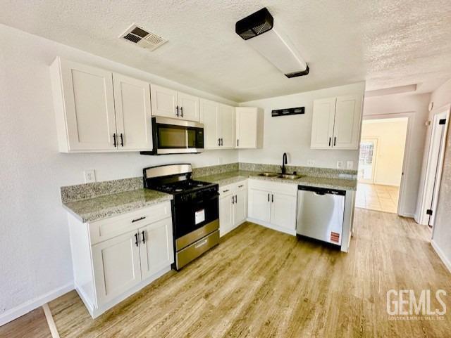 Undisclosed Address Bakersfield, CA 93308 - Photo 5 of 16 a kitchen with granite countertop a stove top oven a sink a counter space and cabinets
