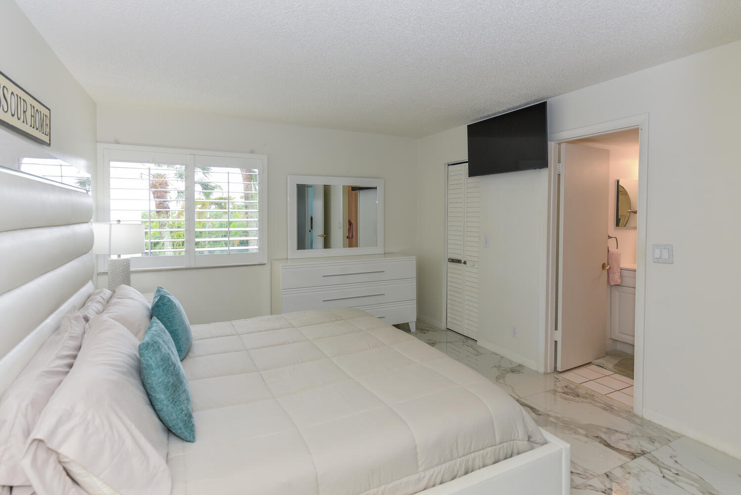 1605 Highway 1, Unit V4206 Jupiter, FL 33477 - Photo 13 of 30 a spacious bedroom with a large bed and a flat tv screen