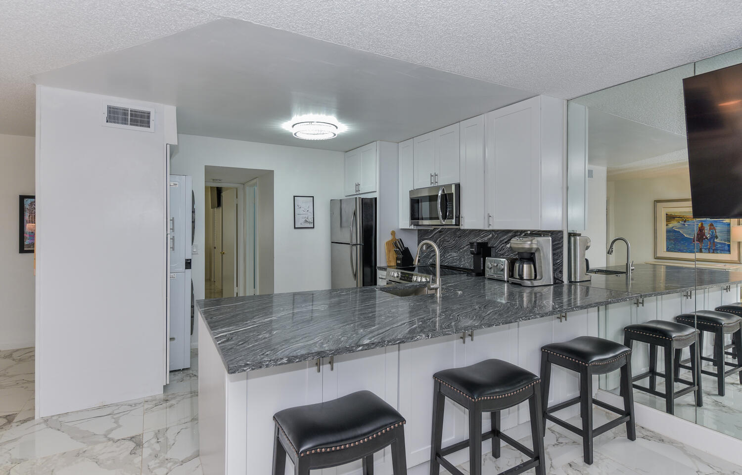1605 Highway 1, Unit V4206 Jupiter, FL 33477 - Photo 2 of 30 a kitchen with granite countertop a table chairs microwave and sink