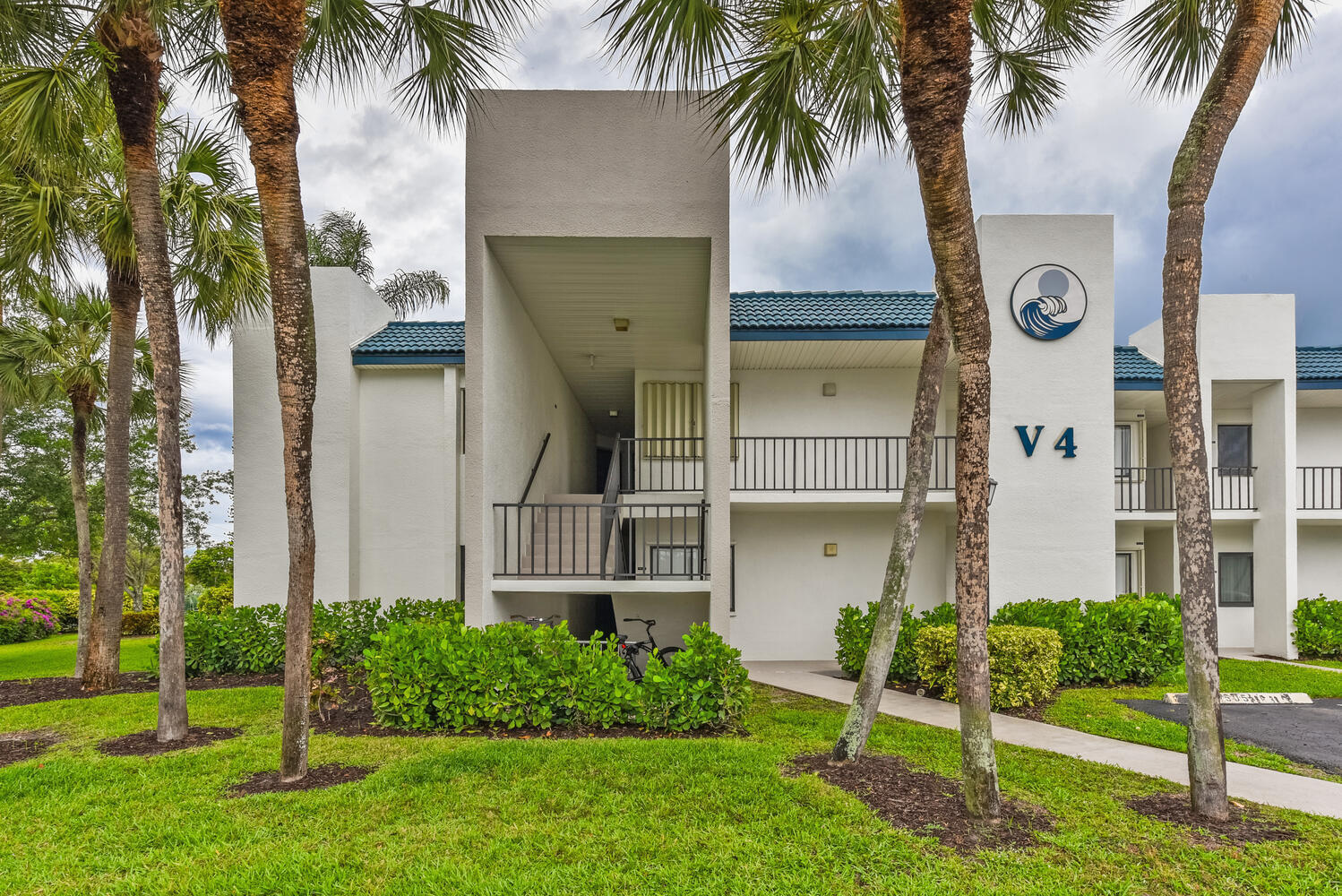 1605 Highway 1, Unit V4206 Jupiter, FL 33477 - Photo 21 of 30 front view of house with a yard and palm trees