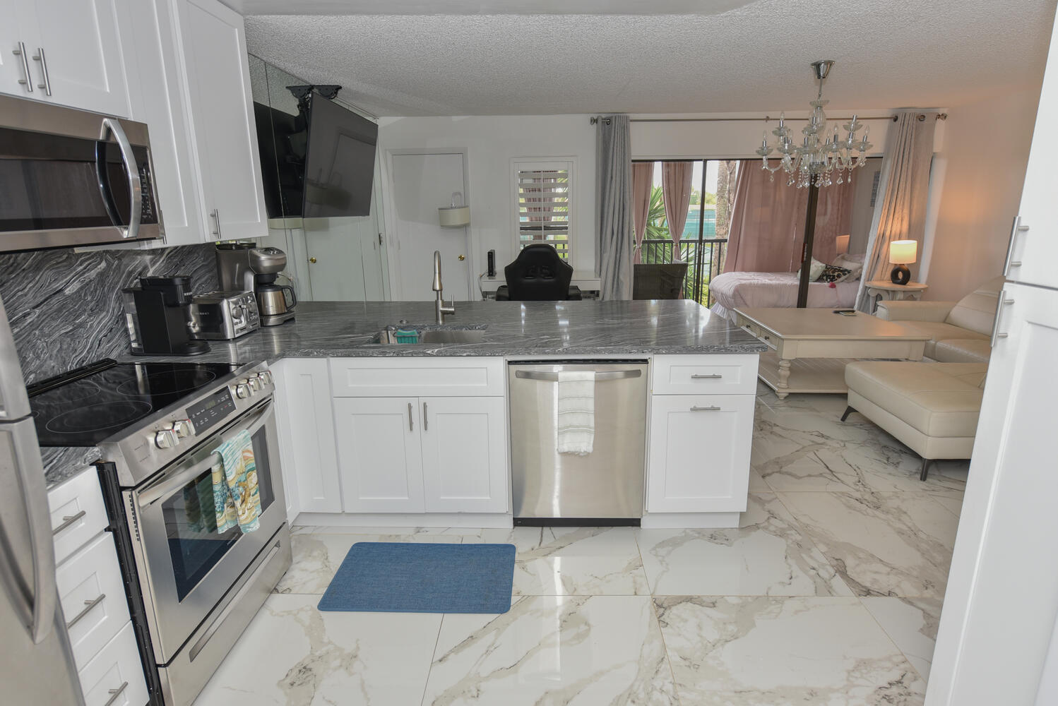 1605 Highway 1, Unit V4206 Jupiter, FL 33477 - Photo 3 of 30 a kitchen with stainless steel appliances granite countertop a sink stove and microwave