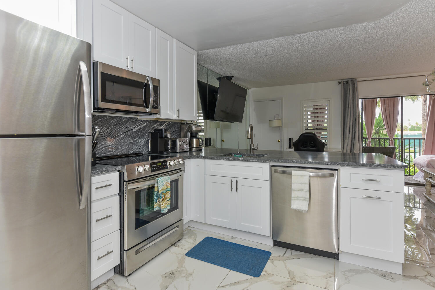 1605 Highway 1, Unit V4206 Jupiter, FL 33477 - Photo 4 of 30 a kitchen with white cabinets and stainless steel appliances