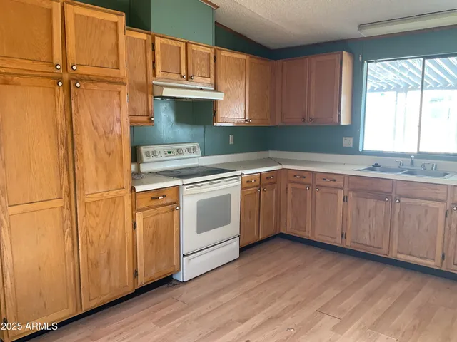 a kitchen with granite countertop white cabinets and white appliances
