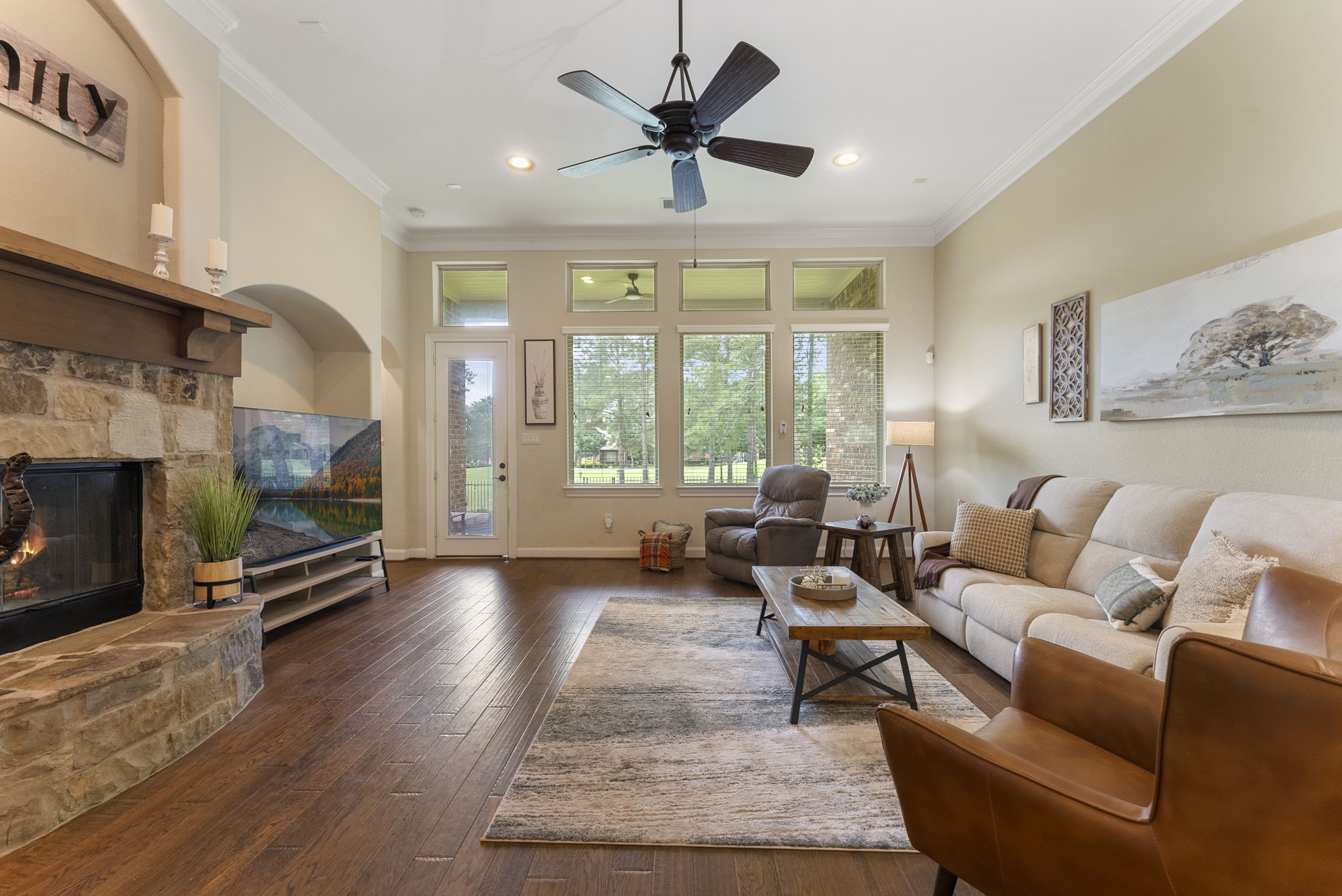4787 Jackson Square Drive Conroe, TX 77304 - Photo 5 of 35 A family room that checks every box for comfort, style, and togetherness. Gleaming hardwood floors set the stage for a warm, inviting ambiance, while a stunning wall of windows floods the space with natural light, creating a seamless connection to the outdoors.