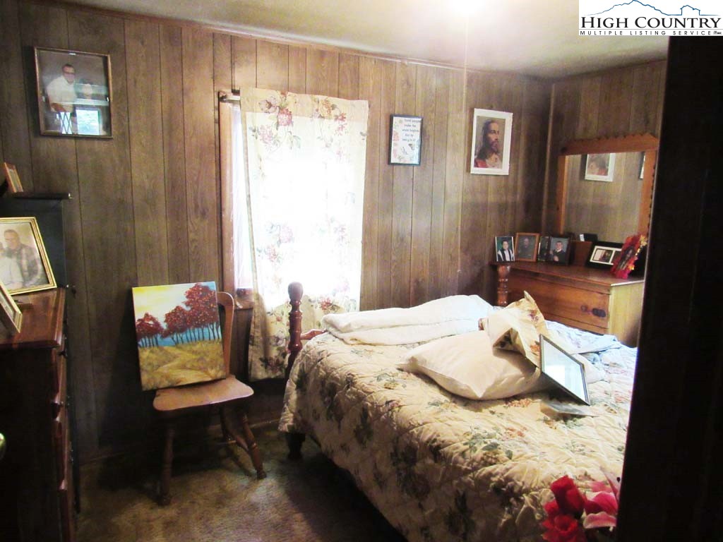 458 Paul Goodman Road Fleetwood, NC 28626 - Photo 15 of 22 a bedroom with a bed window and a chair
