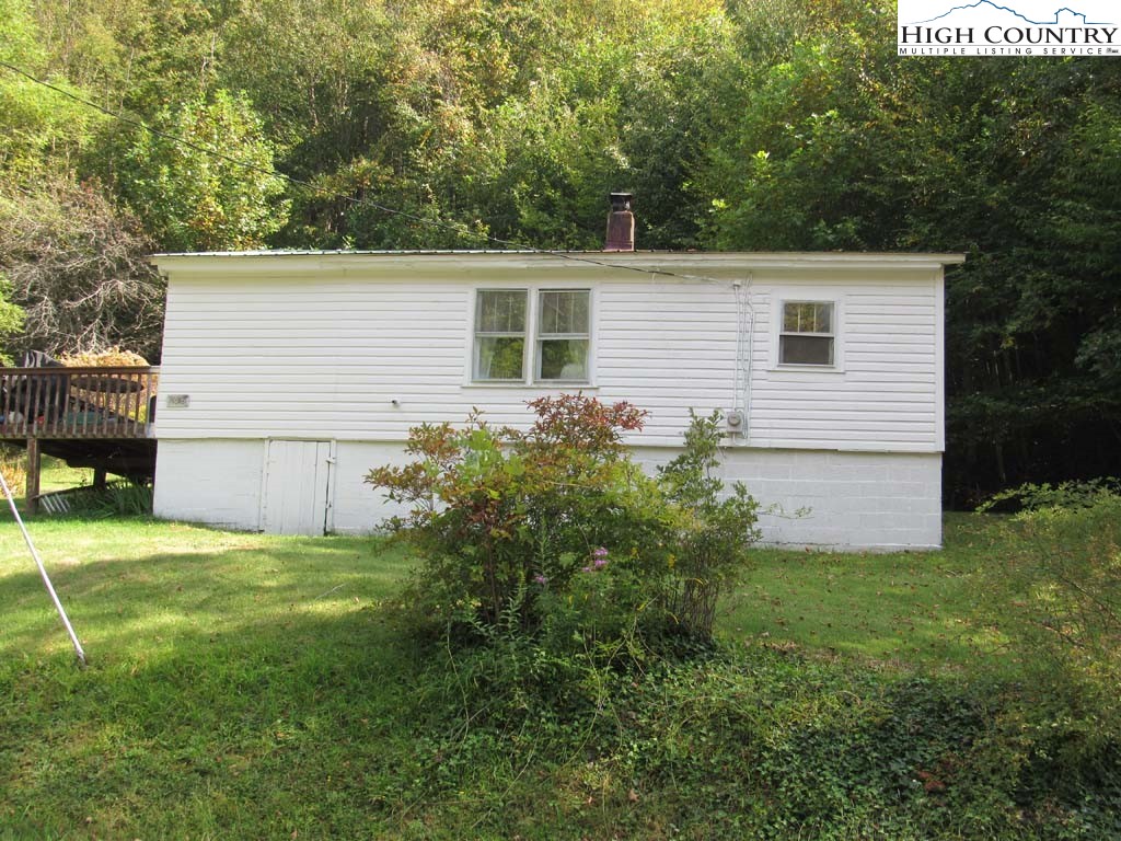 458 Paul Goodman Road Fleetwood, NC 28626 - Photo 3 of 22 a backyard of a house with plants and large tree