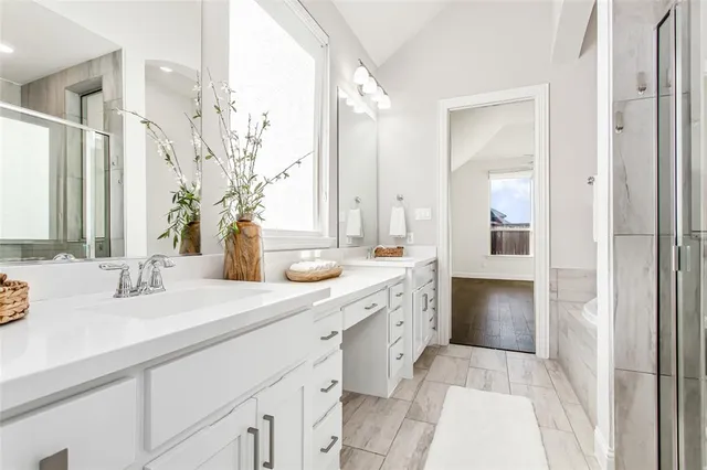 a spacious bathroom with a sink double vanity granite and a mirror