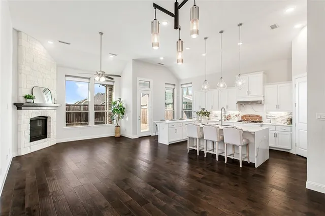 a kitchen with stainless steel appliances a white table chairs and a refrigerator