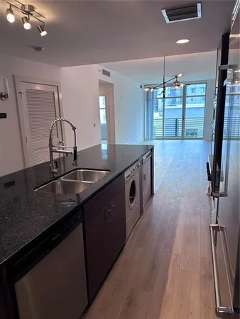 a kitchen with kitchen island a sink appliances and a counter top space