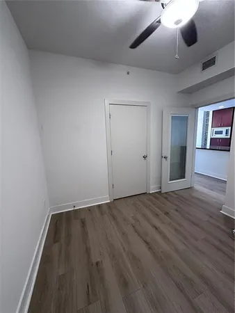an empty room with wooden floor and windows
