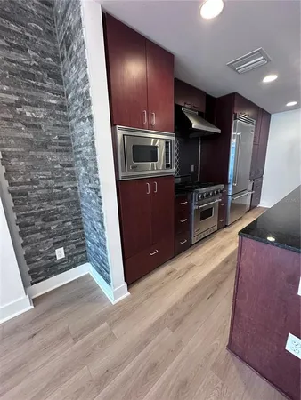 a living room with stainless steel appliances wooden floor and furniture