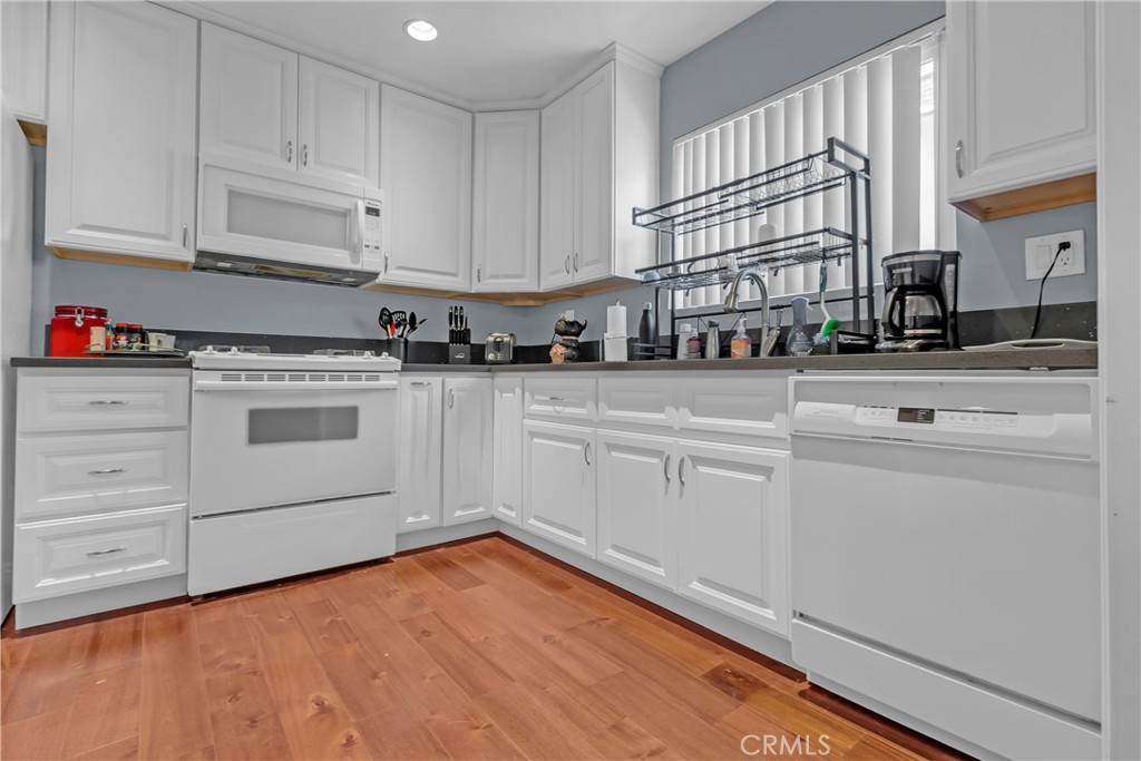 12334 Chandler Boulevard, Unit C Valley Village, CA 91607 - Photo 6 of 30 a kitchen with granite countertop white cabinets and white appliances