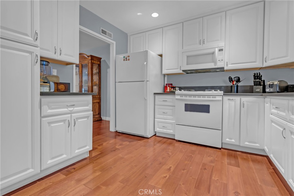 12334 Chandler Boulevard, Unit C Valley Village, CA 91607 - Photo 7 of 30 a kitchen with white cabinets and white appliances