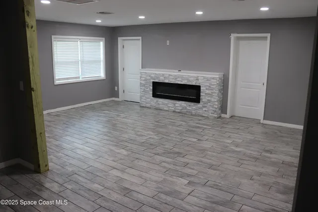 an empty room with wooden floor and fireplace