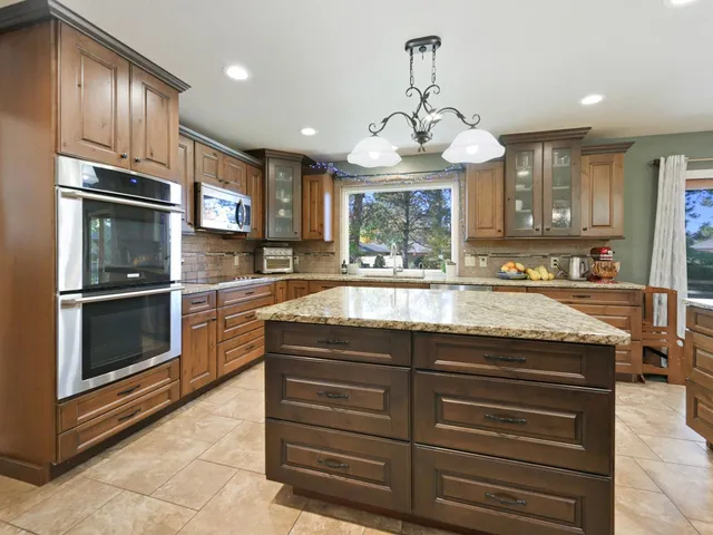 a dining area with a table chairs and a kitchen view