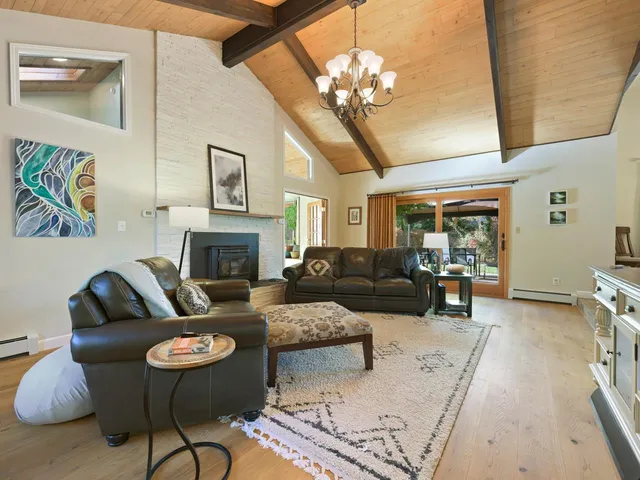 a living room with furniture chandelier and a fireplace