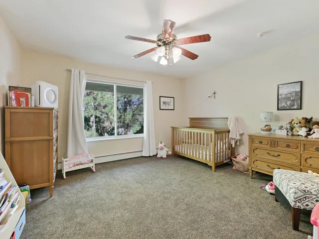 a view of a patio with a table and chairs under an umbrella with a small yard