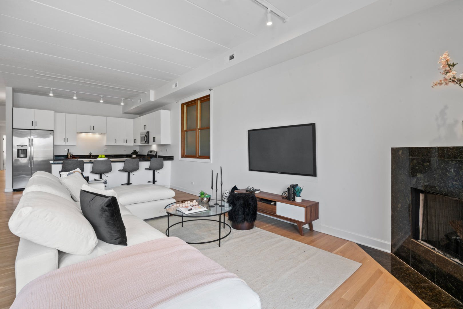 1332 West Madison Street, Unit 2E Chicago, IL 60607 - Photo 13 of 26 a living room with furniture a flat screen tv and a fireplace