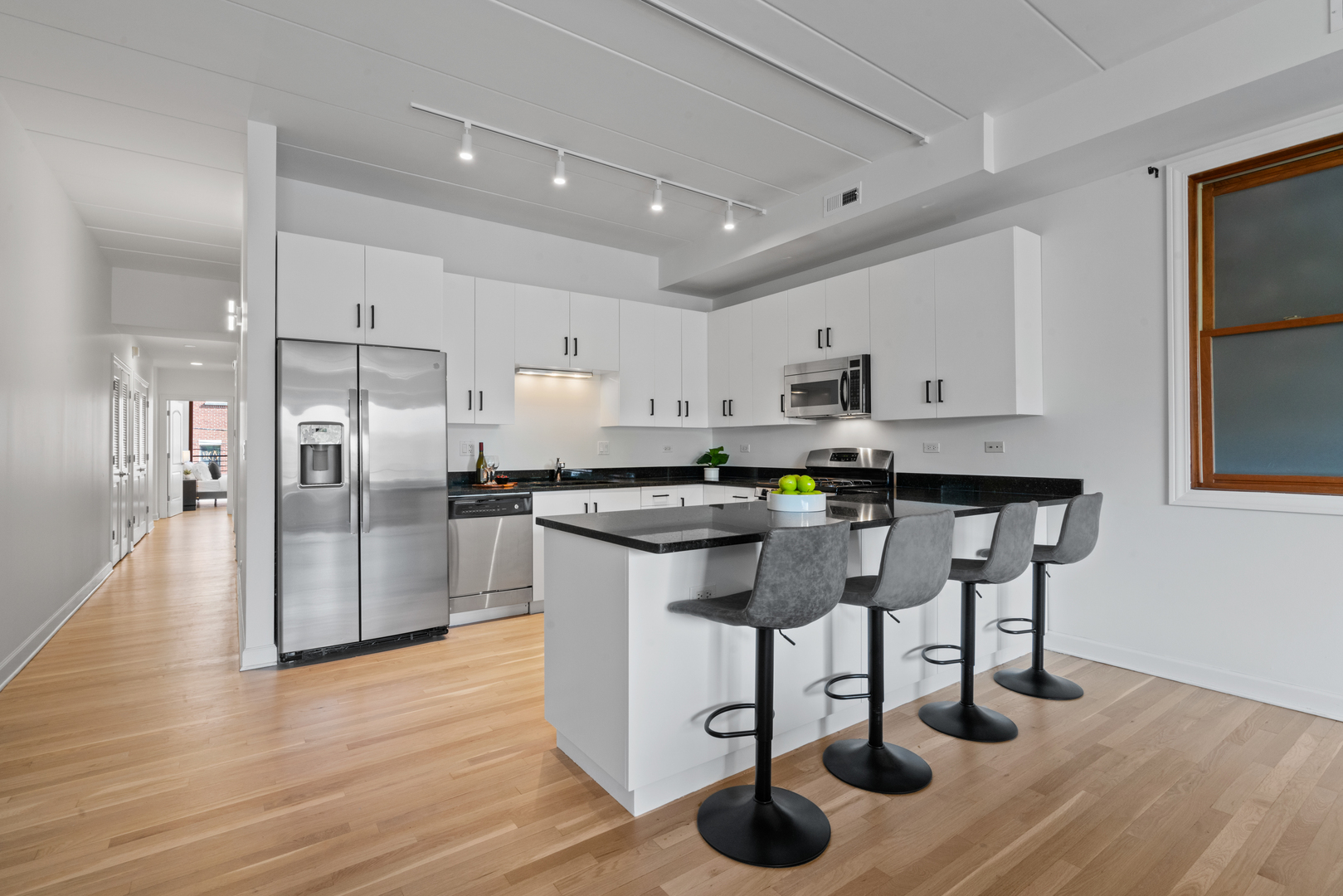 1332 West Madison Street, Unit 2E Chicago, IL 60607 - Photo 2 of 26 a kitchen with stainless steel appliances granite countertop a table chairs refrigerator sink and cabinets