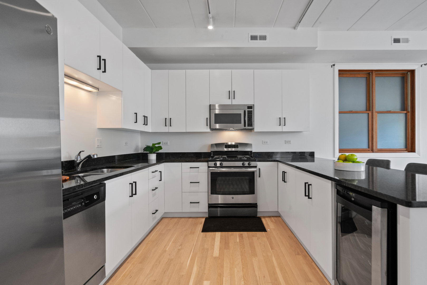 1332 West Madison Street, Unit 2E Chicago, IL 60607 - Photo 4 of 26 a kitchen with stainless steel appliances a stove sink and cabinets