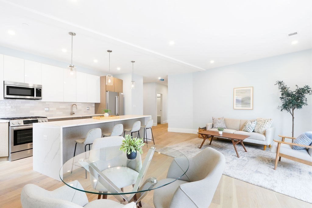 21 Glen Road, Unit 7 Boston, MA 02130 - Photo 5 of 15 a kitchen with a table chairs stove and kitchen island