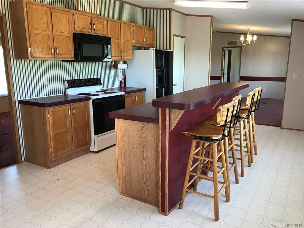 5730 East Bandys Cross Road Catawba, NC 28609 - Photo 8 of 21 a kitchen with stainless steel appliances kitchen island granite countertop a refrigerator a stove a microwave oven with white cabinets