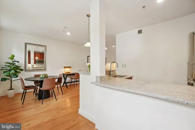 a view of dining table chairs and entryway with wooden floor