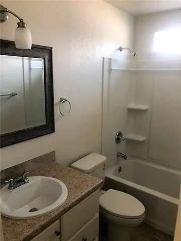 a view of a room with wooden floor and a ceiling fan