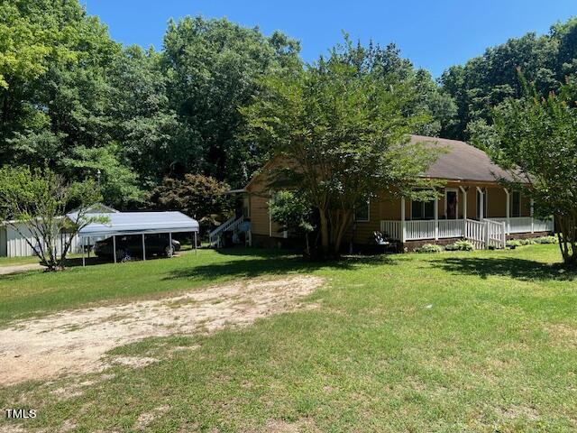 5368 Elevation Road Benson, NC 27504 - Photo 2 of 40 a view of a patio with a table and chairs under an umbrella
