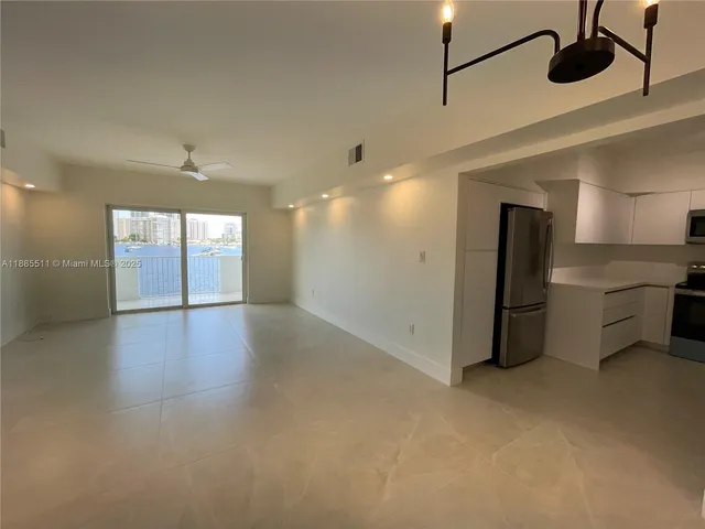 an empty room with windows and ceiling fan