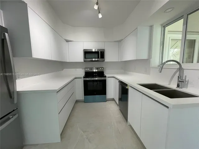 a kitchen with sink a microwave and stove