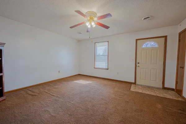 an empty room with closet and ceiling fan