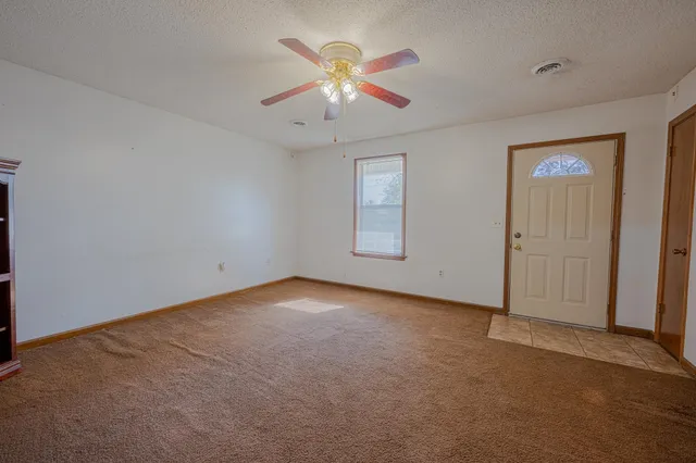an empty room with closet and ceiling fan