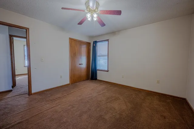 an empty room with closet and windows