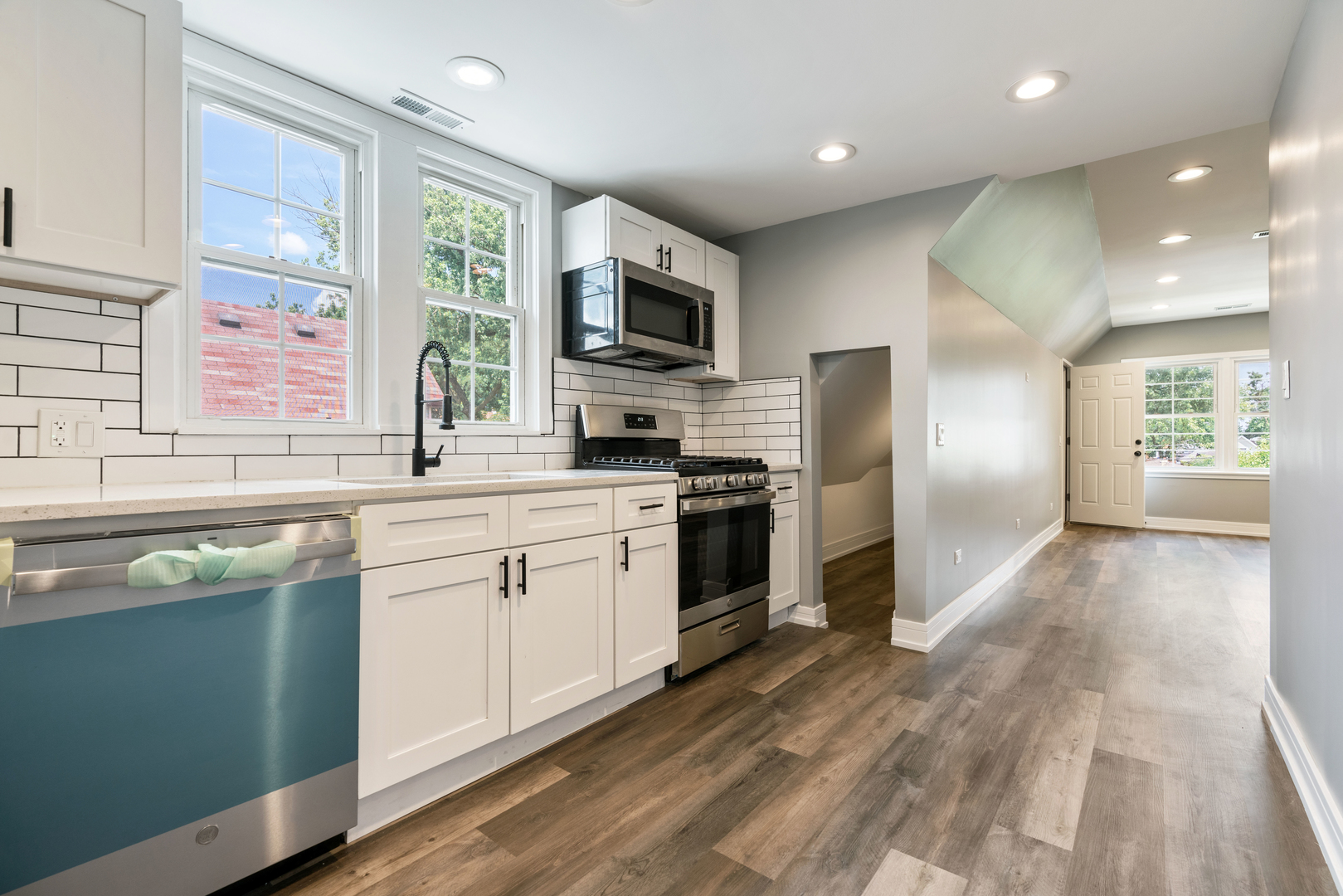 4624 North Springfield Avenue Chicago, IL 60625 - Photo 41 of 44 a kitchen with stainless steel appliances granite countertop a refrigerator a sink dishwasher a stove and white cabinets with wooden floor