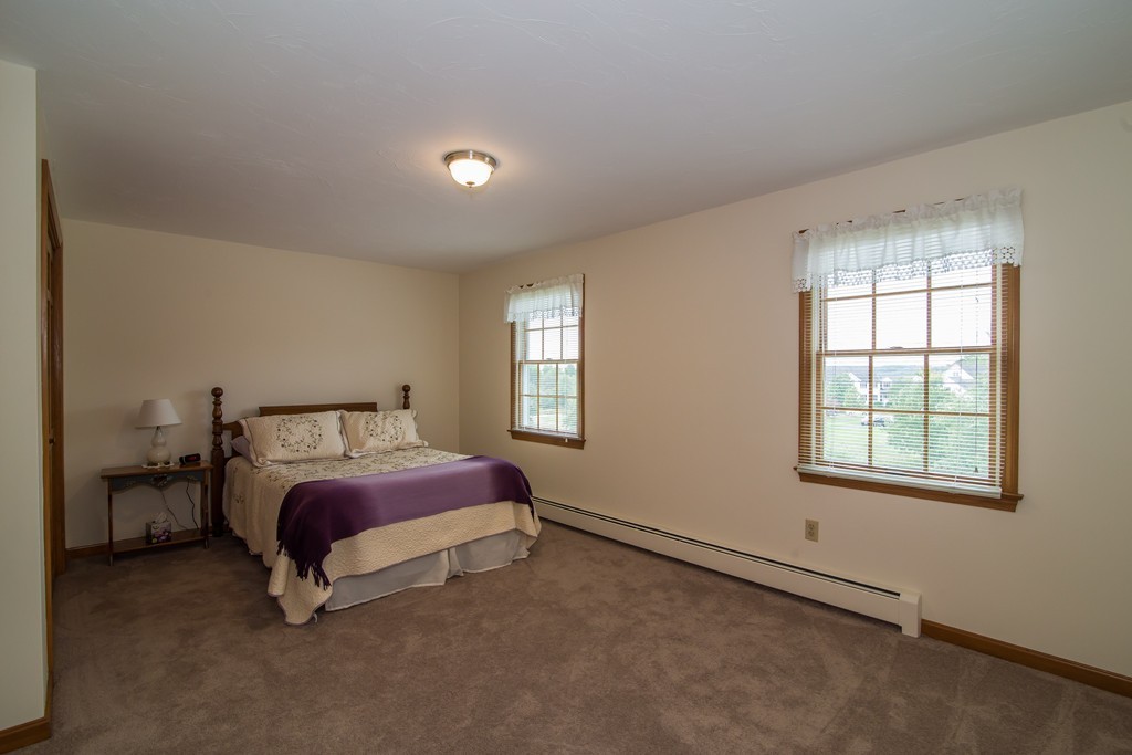 64 Chamberlain Road Westford, MA 01886 - Photo 15 of 27 a spacious bedroom with a bed and a window