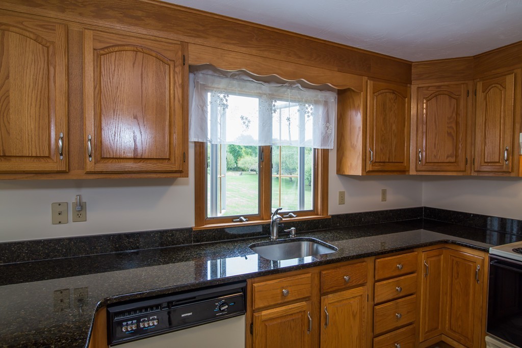 64 Chamberlain Road Westford, MA 01886 - Photo 5 of 27 a kitchen with granite countertop cabinets and window