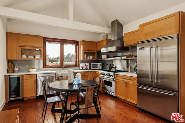 a kitchen with stainless steel appliances a dining table and chairs