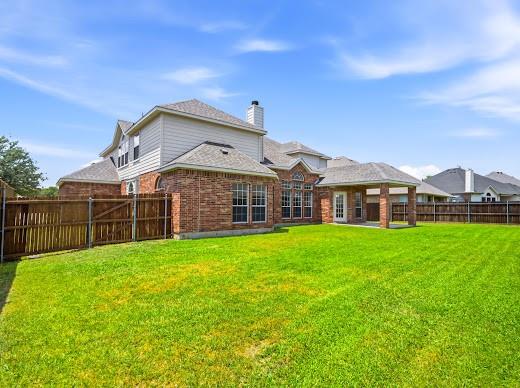 5034 West Fall Drive Midlothian, TX 76065 - Photo 36 of 40 Expansive backyard featuring a large green lawn, full brick exterior, covered patio, and a privacy fence